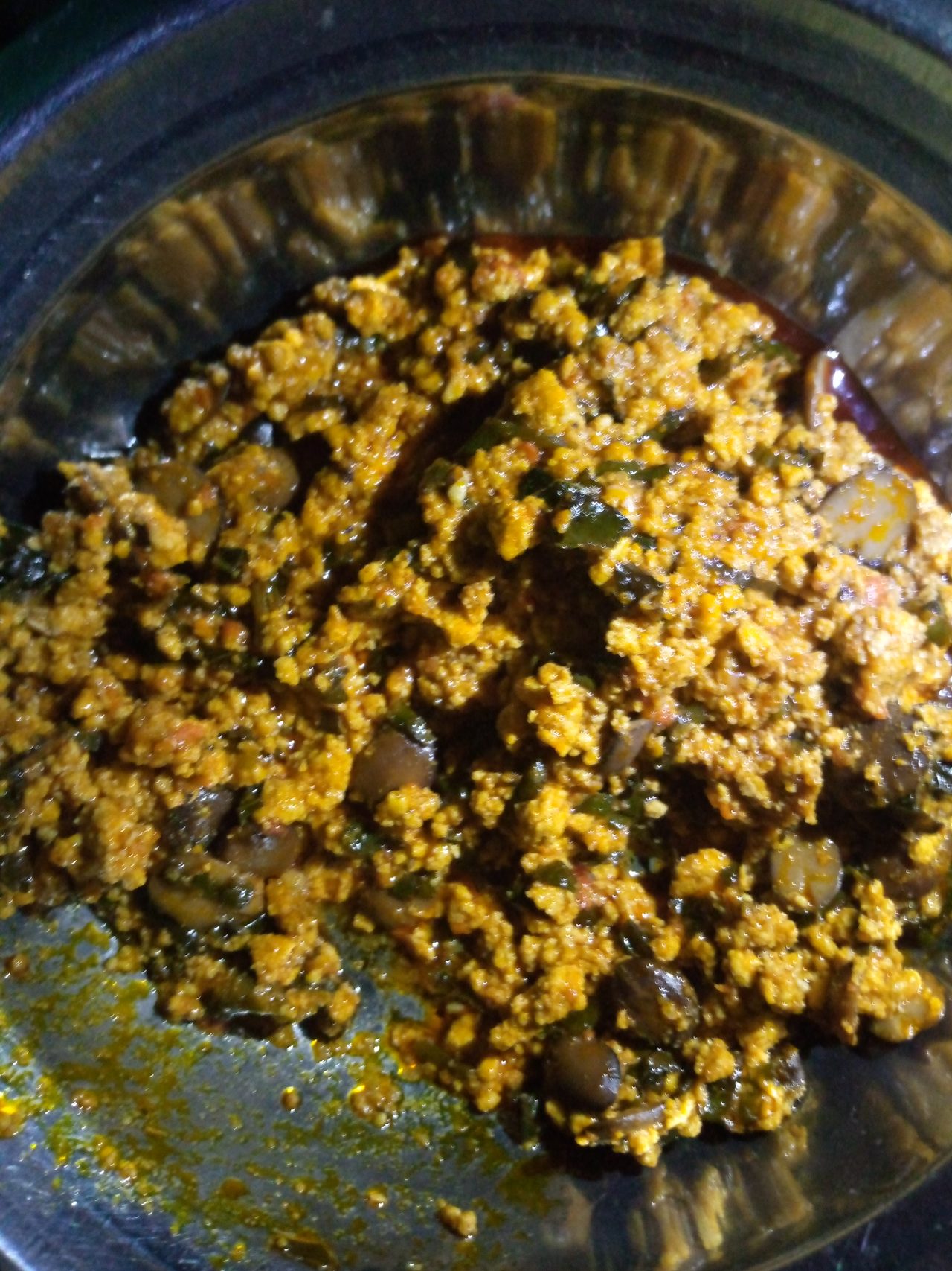Assiette de sauce egusi colorée par l'huile de palme rouge